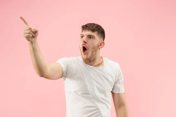 O jovem homem atraente olhando surpreendido isolado em rosa — Fotografia de Stock