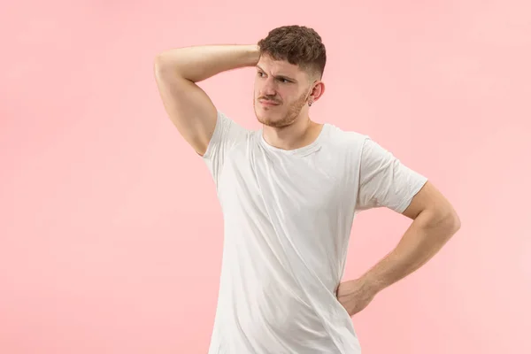 Schöner Mann sieht überrascht und verwirrt isoliert auf rosa — Stockfoto