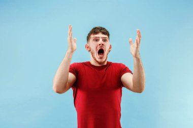 Şaşırmış görünen çekici adam izole mavi genç