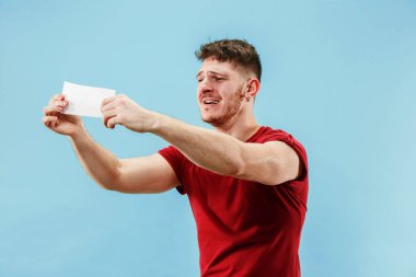 Bir sürpriz ifade bahis fişinde mavi arka plan ile genç çocuk