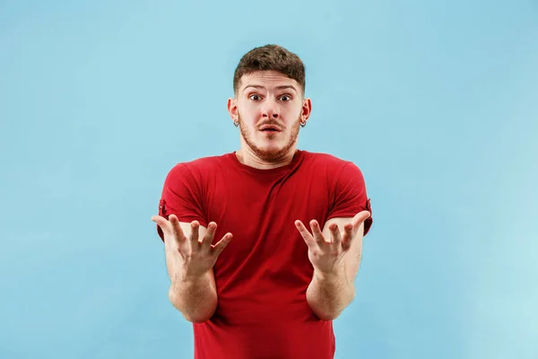 O jovem atraente homem olhando suprised isolado em azul — Fotografia de Stock