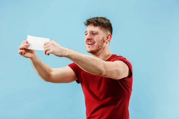 Jongen met een verbaasd expressie inzet slip op blauwe achtergrond — Stockfoto