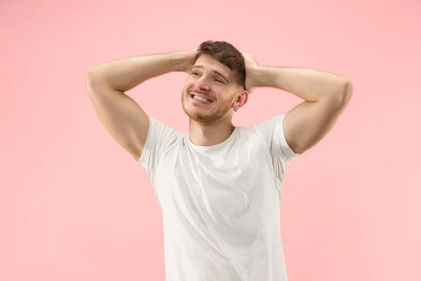 O empresário feliz de pé e sorrindo contra fundo rosa . — Fotografia de Stock