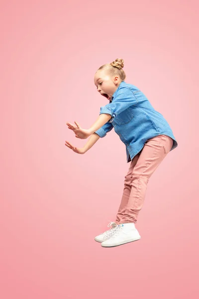 Νέοι φοβάται Καυκάσιος έφηβος κορίτσι άλματα στον αέρα, απομονώνονται σε φόντο ροζ στούντιο. — Φωτογραφία Αρχείου