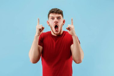 Şaşırmış görünen çekici adam izole mavi genç