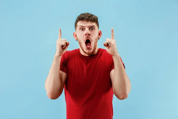 The young attractive man looking suprised isolated on blue — Stock Photo, Image