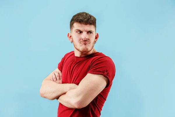 El joven emocional triste hombre enojado en fondo de estudio azul — Foto de Stock