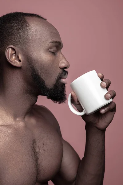 Afrikanischer Mann mit Tasse Tee, isoliert auf rosa Hintergrund — Stockfoto