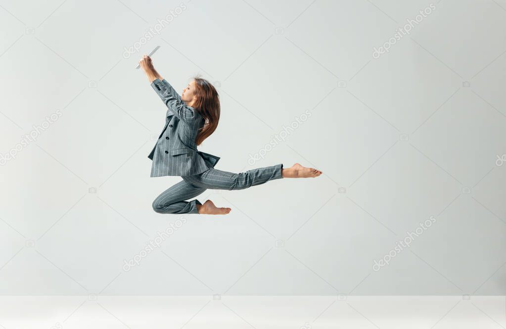 Happy business woman dancing and smiling isolated over white.
