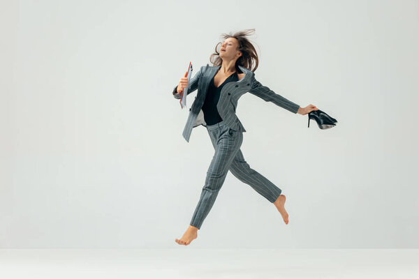 Happy business woman dancing and smiling isolated over white.