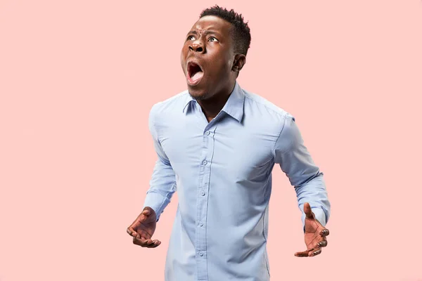 De jonge emotionele boos man schreeuwen op roze studio achtergrond — Stockfoto