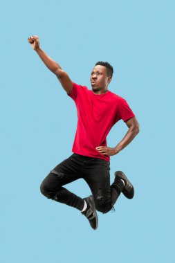 Özgürlük hareketli ve ileriye doğru hareket. Mutlu genç afro adam atlama şaşırttı