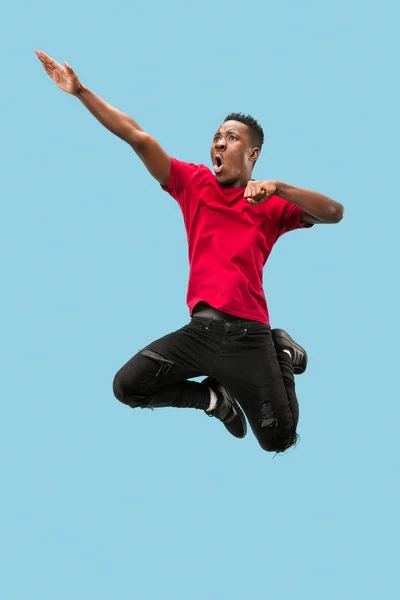 Свобода передвижения и движения вперед. Счастливый удивленный молодой афро-человек прыгает — стоковое фото