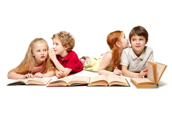 As crianças menino e meninas deitado com livros isolados em branco — Fotografia de Stock