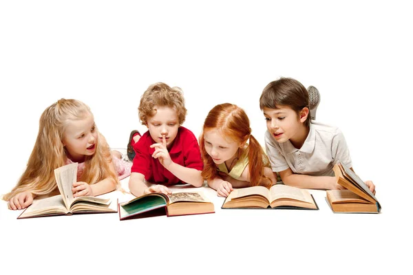 De kinderen jongen en meisjes leggen met boeken geïsoleerd op wit — Stockfoto