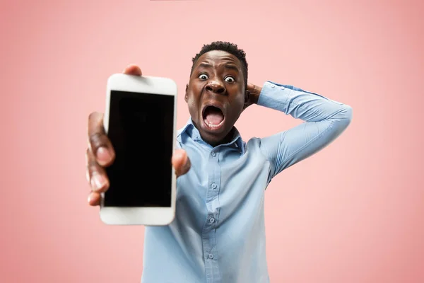 Retrato interior de atractivo joven negro sosteniendo teléfono inteligente en blanco — Foto de Stock