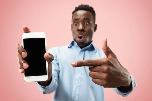 Retrato interno de atraente jovem negro segurando smartphone em branco — Fotografia de Stock