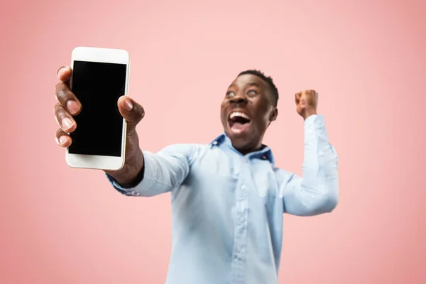 Beltéri portré vonzó fiatal fekete férfi tartja üres smartphone — Stock Fotó