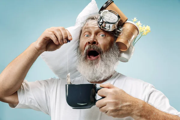 Hombre cansado durmiendo en casa con demasiado trabajo. Empresario aburrido con almohada y reloj de arena — Foto de Stock