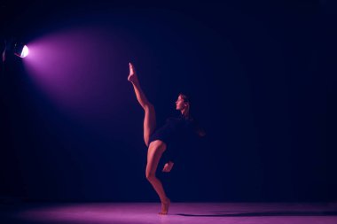 Genç kadın balet neon ışıkları studio arka plan üzerinde.