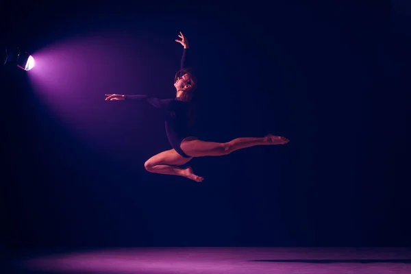 Jonge vrouwelijke balletdanser op neonlichten studio achtergrond. — Stockfoto