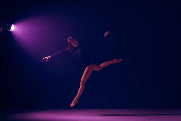 Young female ballet dancer on neon lights studio background. — Stock Photo, Image