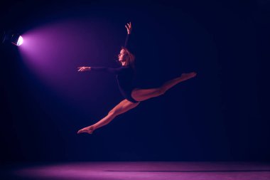 Genç kadın balet neon ışıkları studio arka plan üzerinde.