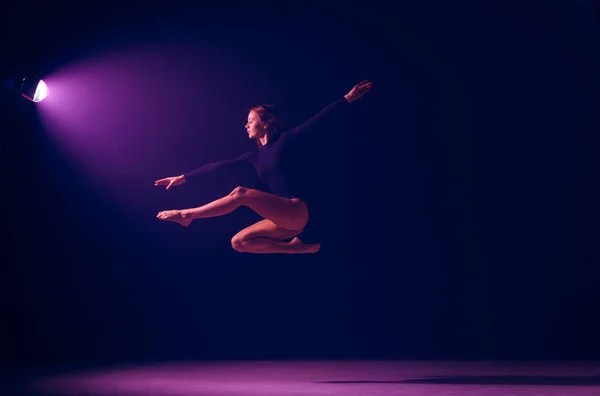 Jonge vrouwelijke balletdanser op neonlichten studio achtergrond. — Stockfoto