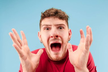 - Kazandım. Kazanan mutlu adam, kazanan olmayı kutluyor. Mavi stüdyo arka planında Kafkas erkek modelinin dinamik görüntüsü. Zafer, zevk konsepti. İnsan yüz duyguları konsepti. Moda renkleri