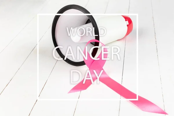 Η παγκόσμια ημέρα καρκίνου του κειμένου και ένα ροζ κορδέλα σε ένα φόντο του πίνακα — Φωτογραφία Αρχείου