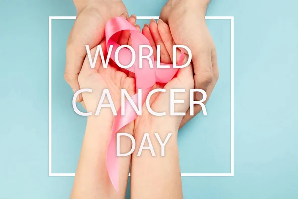 El día mundial del cáncer de texto y una cinta rosa sobre un fondo de mesa — Foto de Stock