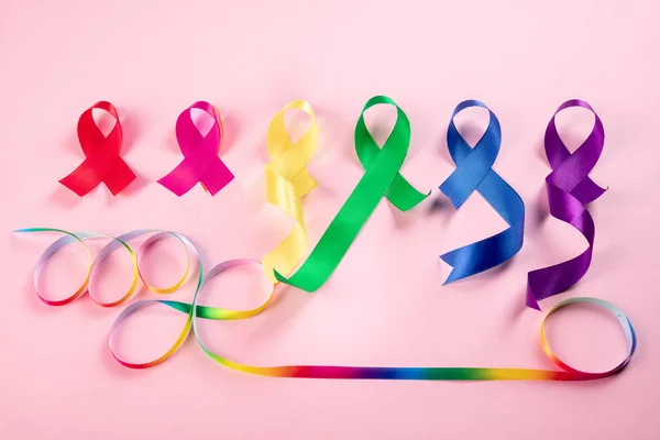 Всемирный день борьбы с раком 4 февраля. Красочные ленты осознания на розовом фоне — стоковое фото
