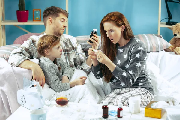 Los padres jóvenes con hija enferma en casa. La familia enferma . —  Fotos de Stock