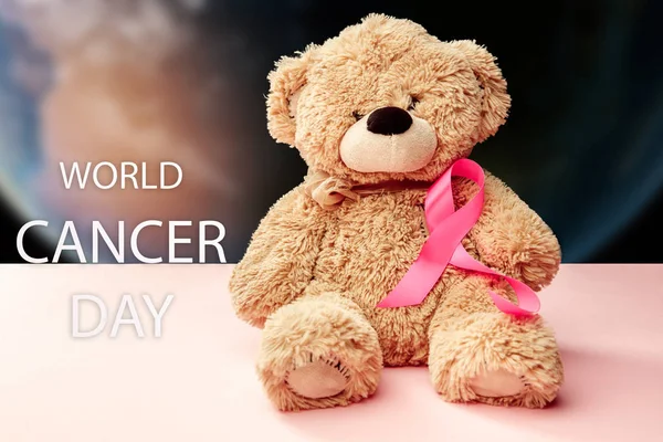 Il giorno mondiale di cancro di testo e un nastro rosa su uno sfondo di tavolo — Foto Stock