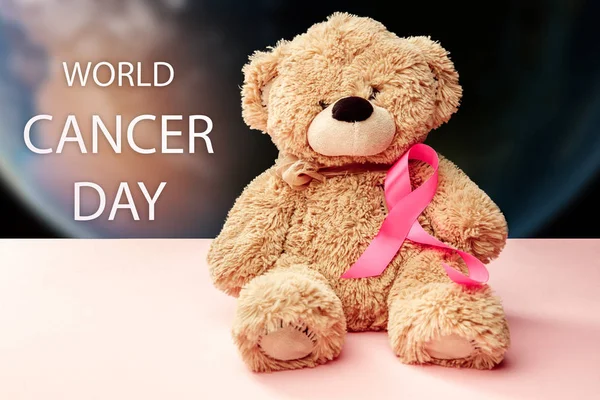 El día mundial del cáncer de texto y una cinta rosa sobre un fondo de mesa — Foto de Stock