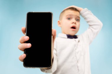 Kapalı boş smartphone tutan çekici genç çocuk portresi