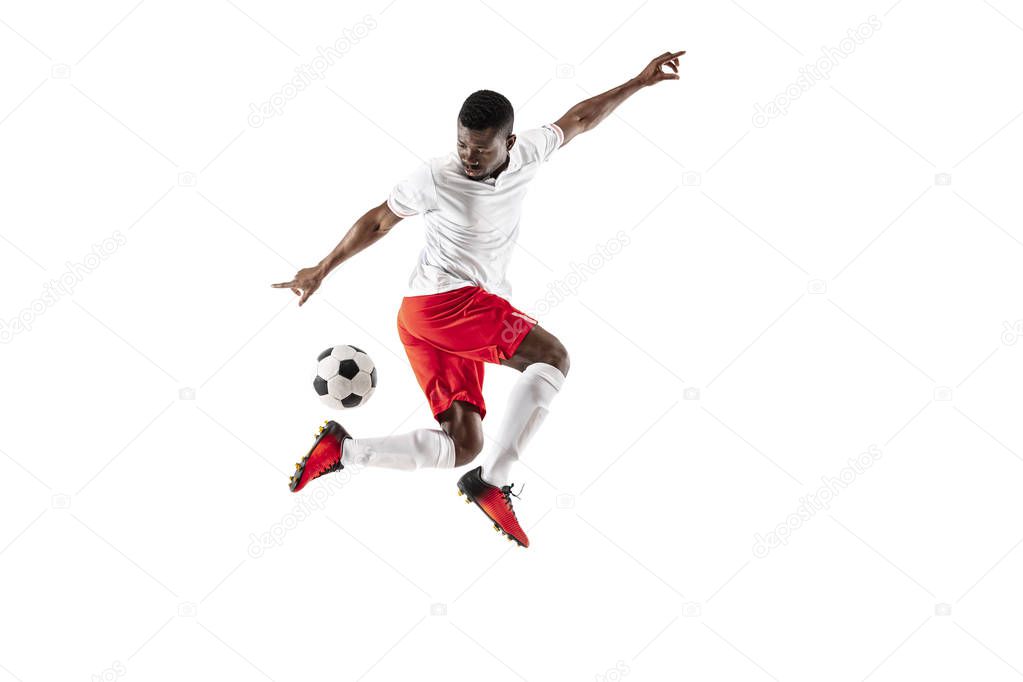 Professional african american football soccer player in motion isolated on white studio background. Fit jumping man in action, jump, movement at game.