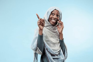 Yüzünde mutlu bir gülümseme ile gri hijab giyen güzel genç siyahi Müslüman kız.