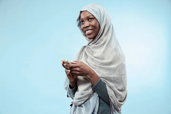 La bella giovane ragazza musulmana nera vestita di hijab grigio, con un sorriso felice sul viso . — Foto Stock