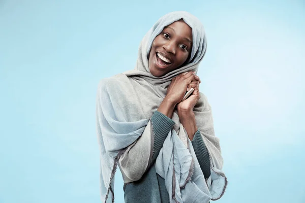 La bella giovane ragazza musulmana nera vestita di hijab grigio, con un sorriso felice sul viso . — Foto Stock