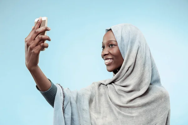 Den vakre unge svarte muslimske jenta med grå hijab, med et lykkelig smil i ansiktet . – stockfoto
