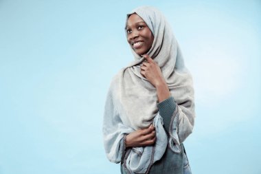 Yüzünde mutlu bir gülümseme ile gri hijab giyen güzel genç siyahi Müslüman kız.