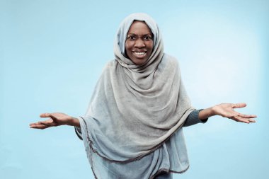 Yüzünde mutlu bir gülümseme ile gri hijab giyen güzel genç siyahi Müslüman kız.
