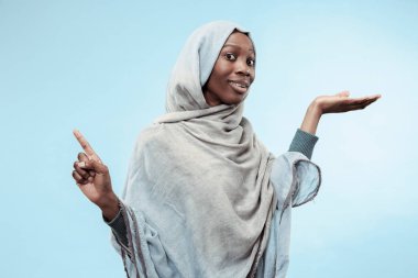 Yüzünde mutlu bir gülümseme ile gri hijab giyen güzel genç siyahi Müslüman kız.