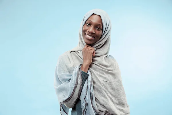 La bella giovane ragazza musulmana nera vestita di hijab grigio, con un sorriso felice sul viso . — Foto Stock