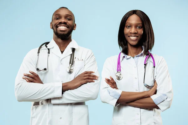 La mujer y el hombre f médicos afro-americanos felices sobre fondo azul —  Fotos de Stock