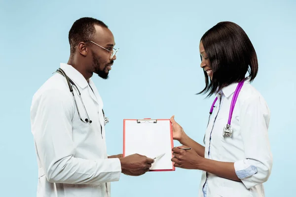 La mujer y el hombre f médicos afro-americanos felices sobre fondo azul —  Fotos de Stock