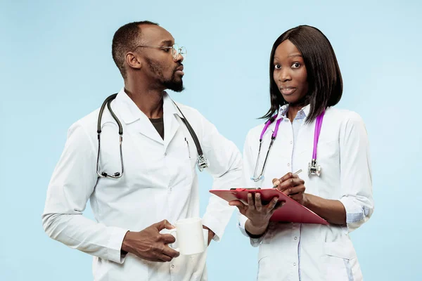 La mujer y el hombre f médicos afro-americanos felices sobre fondo azul —  Fotos de Stock