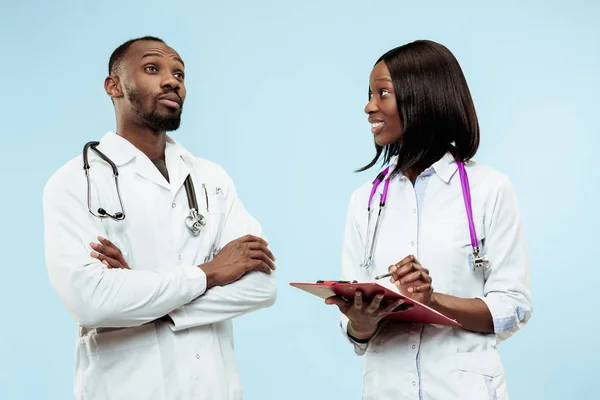 La mujer y el hombre f médicos afro-americanos felices sobre fondo azul —  Fotos de Stock