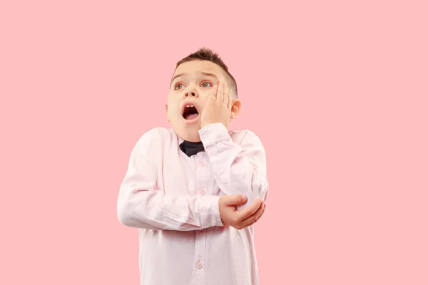 Der junge attraktive Teenie-Junge sieht überrascht isoliert auf rosa — Stockfoto